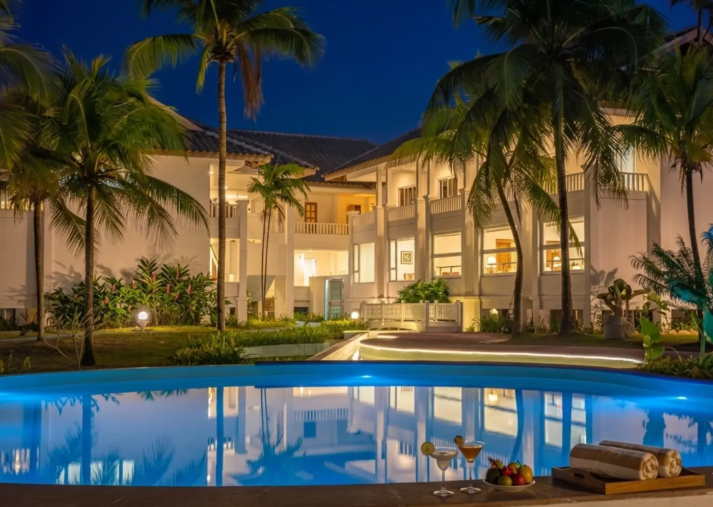 Bidong View Resort lit up at night with palm trees and pool reflections